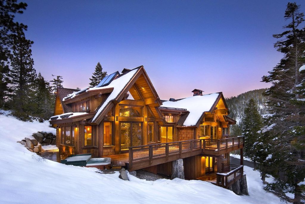 Large wooden lodge surrounded by snow in mountain setting